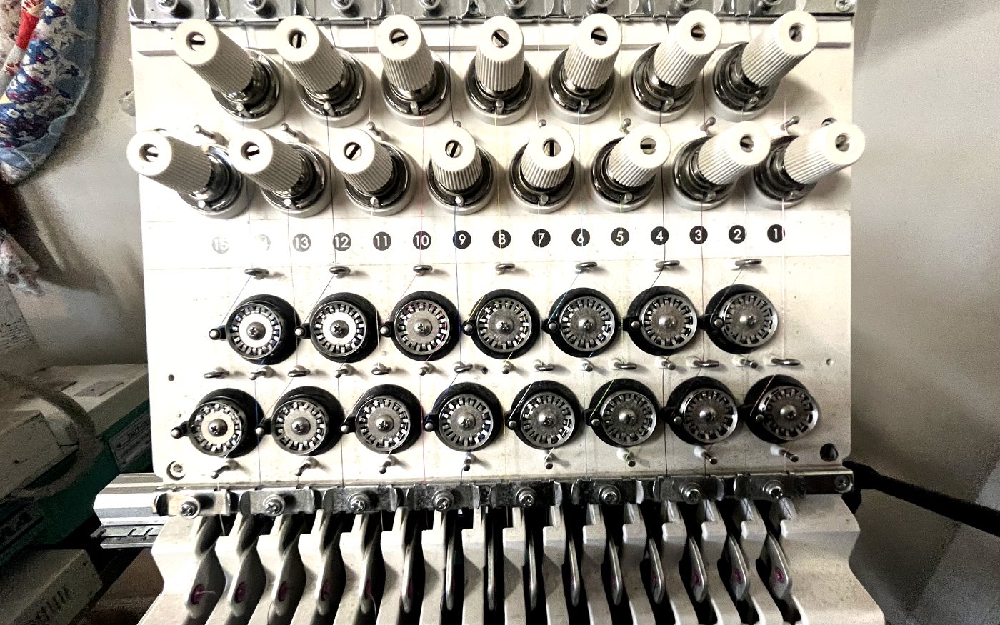 Close-up of embroidery machine needle tensioners