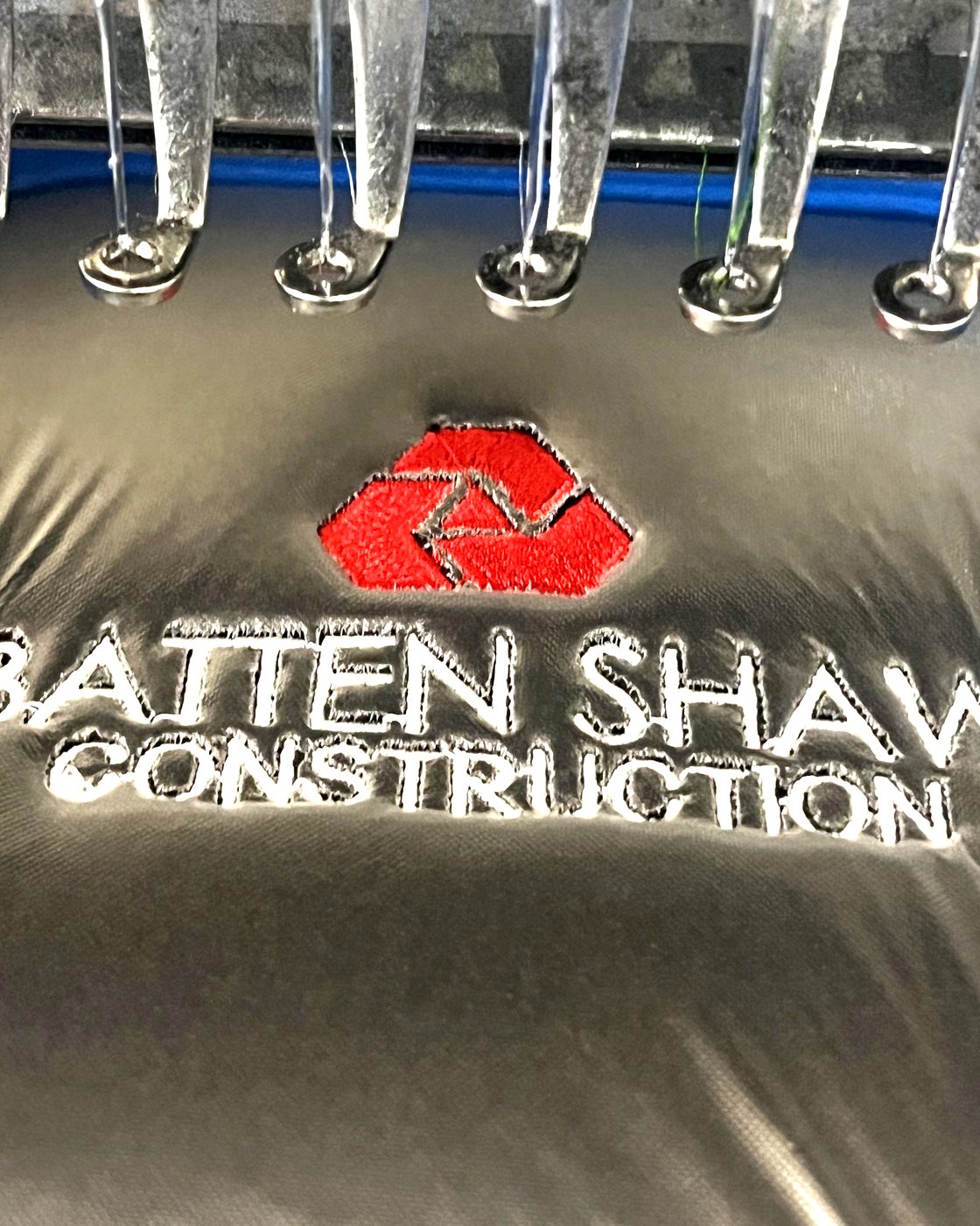 Corporate embroidery detail — Batten Shaw logo stitching in machine